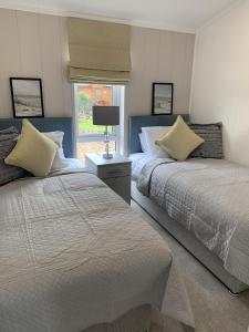 a bedroom with two beds and a window at Cedar 36 Hot Tub in Garton