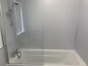 a shower with a glass door in a bathroom at Cedar 36 Hot Tub in Garton