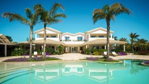 a large house with palm trees and a swimming pool at Sant Efis Hotel in Pula