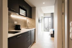 a kitchen with black cabinets and a sink at WYZ Piraeus in Piraeus