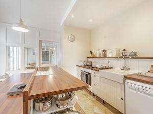 uma cozinha com uma mesa de madeira e uma bancada em Tidal Watch - Uk37851 em Alnmouth