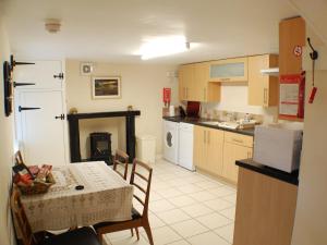 a kitchen with a table and a kitchen with a stove at Tigh Nan Eoin in Aultbea