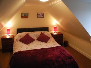 a bedroom with a bed with two lamps on two night stands at Tigh Nan Eoin in Aultbea