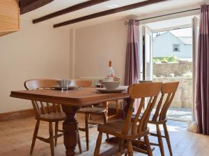 a wooden table and chairs in a room with a window at Woodlands in Laugharne