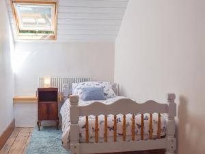 um quarto com uma cama e uma janela em Woodlands em Laugharne