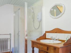 uma casa de banho com um lavatório e um chuveiro em Woodlands em Laugharne