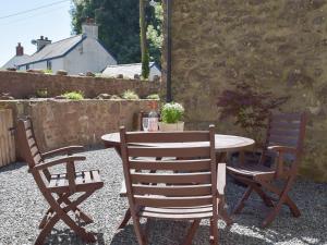 uma mesa e duas cadeiras num pátio em Woodlands em Laugharne