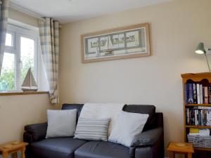 a living room with a blue couch and a book shelf at The Old Boat Store in Totland