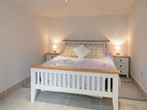 a bedroom with a white bed with two night stands at The Old Rectory Cottage in Great Carlton