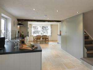 a kitchen and living room with a counter and a table at The Old Rectory Cottage in Great Carlton