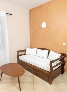 uma cama com almofadas brancas e uma mesa num quarto em Niriides Boutique Apartments em Koufonisia