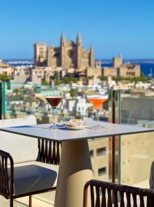 einen Tisch mit zwei Gläsern auf dem Balkon in der Unterkunft Hotel Saratoga in Palma de Mallorca