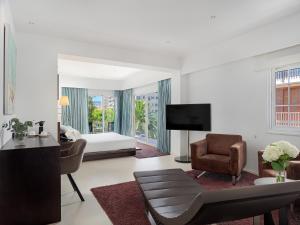 a white living room with a bed and a couch at Hotel Saratoga in Palma de Mallorca