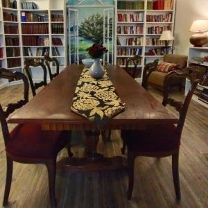 stół jadalny z krzesłami i półką na książki w obiekcie Zarbalı Cunda w mieście Ayvalık