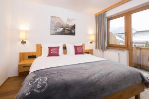 a bedroom with a large bed with red pillows at Haus Sylvia in Reith im Alpbachtal