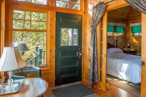 a bedroom with a green door and a bed and a table at FRE-Wil in Lincolnville