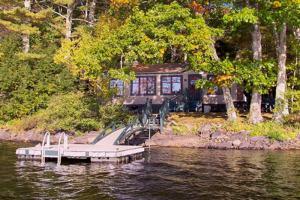 a house on the side of a river with a dock at FRE-Wil in Lincolnville