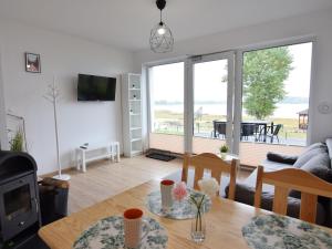 uma sala de estar com uma mesa e vista para o oceano em Modern holiday homes directly on the lake in Kiedrowice em Kiedrowice