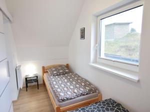 um pequeno quarto com uma cama e uma janela em Modern holiday homes directly on the lake in Kiedrowice em Kiedrowice