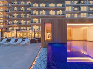 a swimming pool with a hotel in the background at Hotel Saratoga in Palma de Mallorca