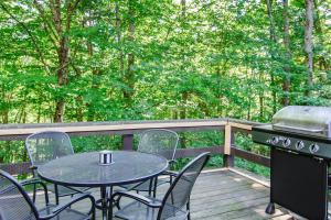 a table and chairs on a deck with a grill at Kingswood 2C Condominium in Quechee