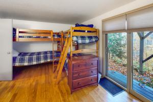 a bedroom with bunk beds and a dresser and a window at Kingswood 2C Condominium in Quechee