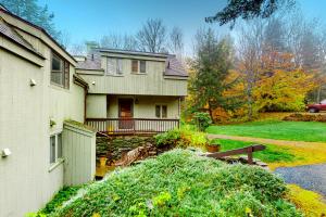 a house with a porch and a yard at Kingswood 2C Condominium in Quechee