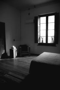 1 dormitorio con cama, ventana y silla en Portón Rojo in 