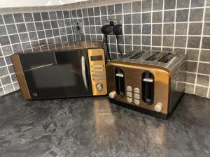 a microwave and a toaster oven sitting on a counter at Beach House East Lodge in Southport