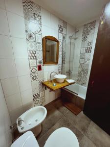 a bathroom with a toilet and a sink and a tub at Portón Rojo in Liebig