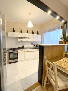 a kitchen with white cabinets and a table and a dining room at 14 Gdynia Centrum - Apartament Mieszkanie dla 4 os in Gdynia