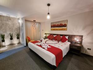 Un dormitorio con una cama grande con almohadas rojas. en Hotel La Gruta, en Arequipa