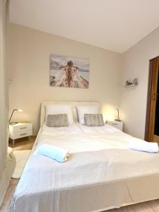 a bedroom with a large white bed with two pillows at 14 Gdynia Centrum - Apartament Mieszkanie dla 4 os in Gdynia