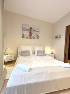 Un dormitorio con una gran cama blanca con dos almohadas. en 14 Gdynia Centrum - Apartament Mieszkanie dla 4 os, en Gdynia