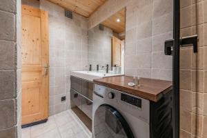 a laundry room with a washing machine and a sink at Appartement Europa in Briançon