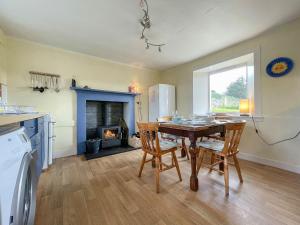 a kitchen with a table and chairs and a fireplace at Dalcharn in Invernaver