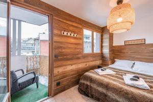 una camera con un letto e una sedia e una finestra di Appartement Europa a Briançon