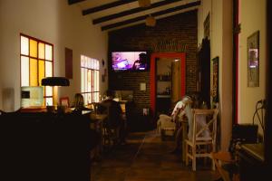 a living room with people sitting in chairs and a tv at Portón Rojo in Liebig