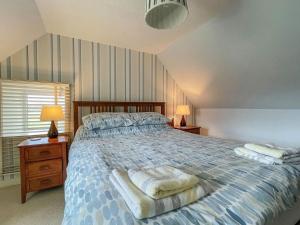 a bedroom with a bed with two lamps and towels on it at Dalcharn in Invernaver