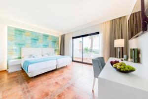 a bedroom with a bed and a table with a bowl of fruit at Aldiana Club Costa del Sol in Alcaidesa
