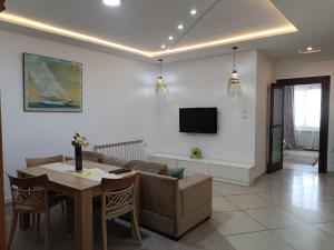 ein Wohnzimmer mit einem Sofa, einem Tisch und einem TV in der Unterkunft Fufa Apartment in Monastir