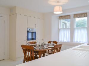 a kitchen with a table and chairs in a kitchen at Garden Cottage in Strachur