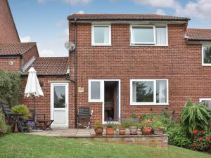 a brick house with white windows and a patio at Sparrows Nest in Preston