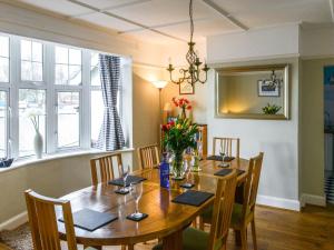 a dining room with a wooden table and chairs at Riverside House in Beccles
