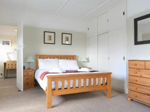 a bedroom with a wooden bed with white pillows at Riverside House in Beccles