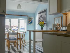 a kitchen with blue walls and a table and chairs at Riverside House in Beccles