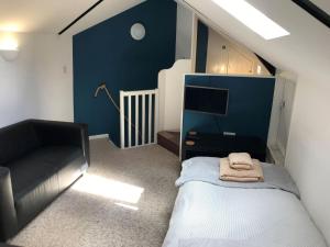 1 dormitorio pequeño con 1 cama y 1 sofá en Church View Cottage Barn en Hatherleigh