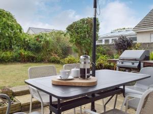 una mesa con una cafetera en el patio en Cartref en St. Davids