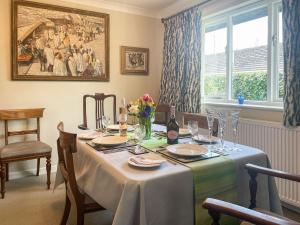 a dining room with a table with flowers and a painting at Millbrook in Bere Regis