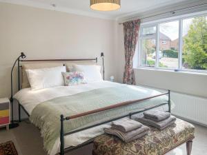 a bedroom with a large bed and a window at Millbrook in Bere Regis